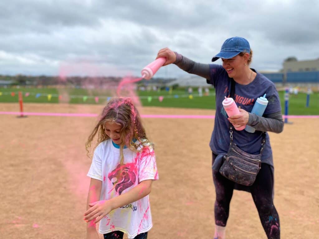 Parent squirting their child during the color run