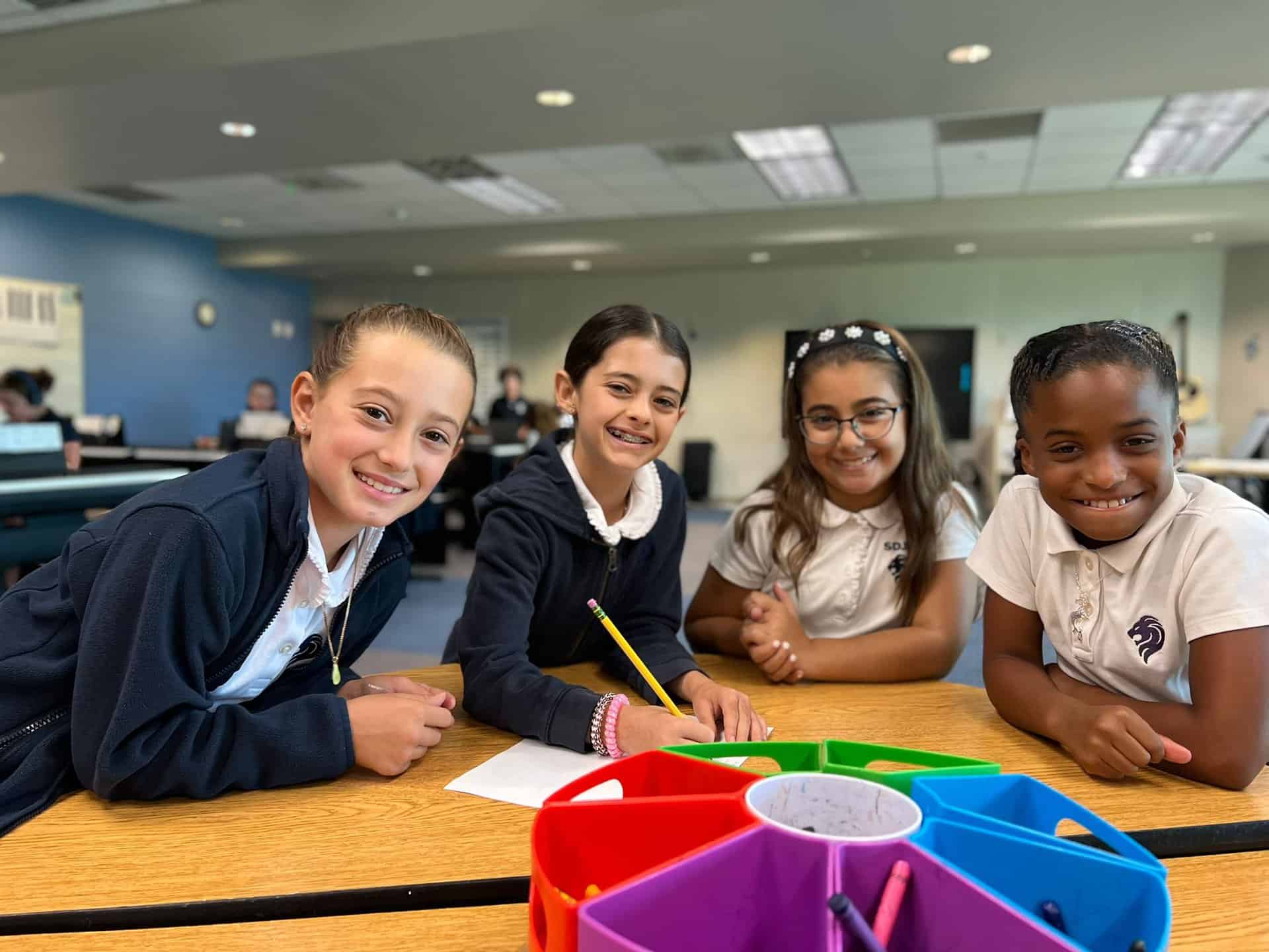 Four Lower School Students take a moment to pose and smile during class
