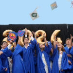 SDJA graduates throwing their hats in the air.