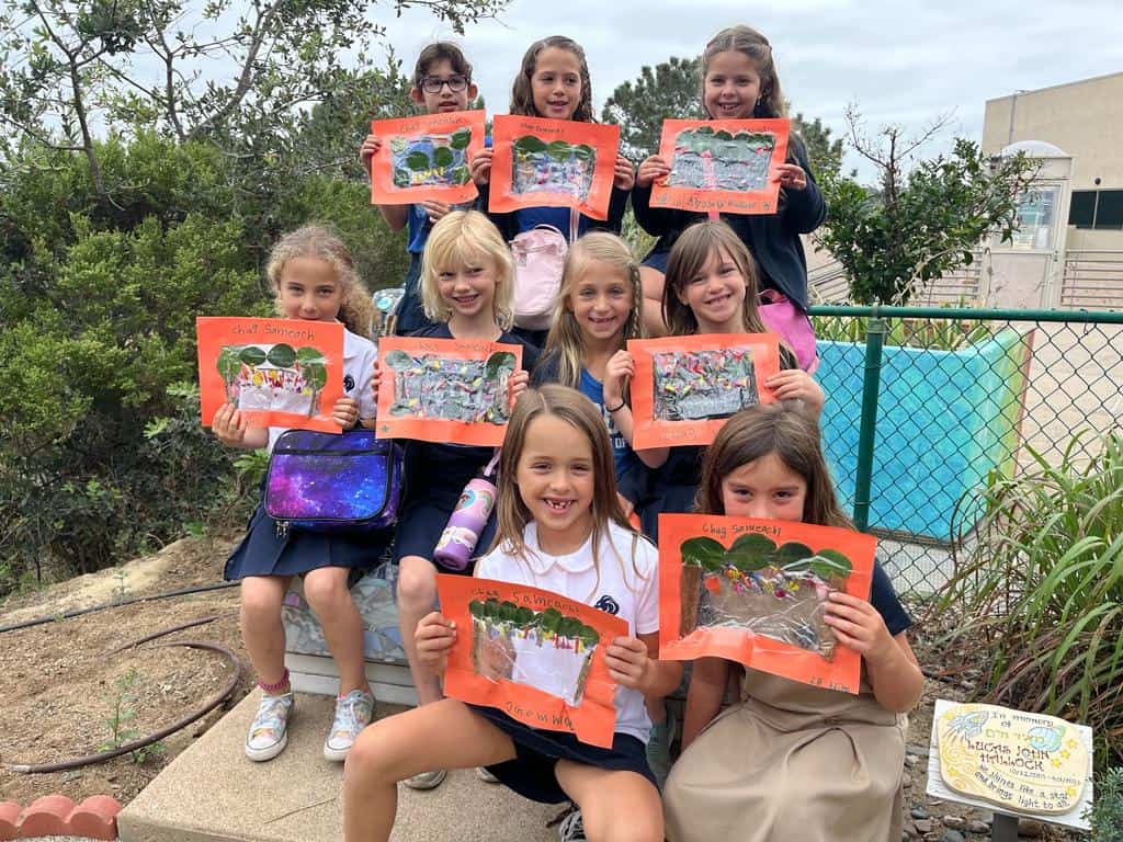 Lower School students holding up an art project they worked on in Levana's Garden