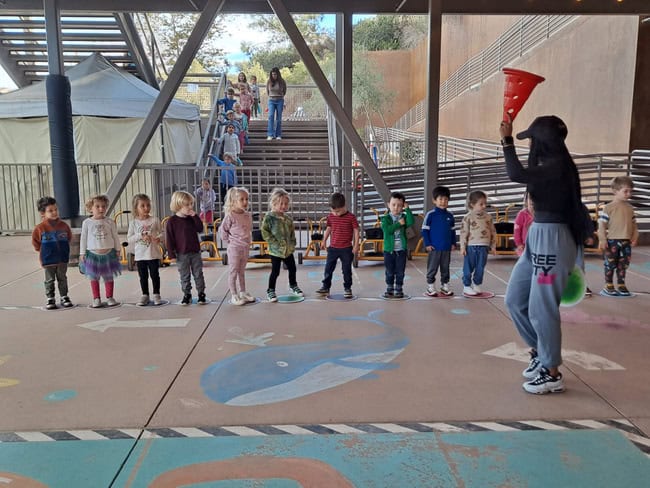 A teacher gives instruction to preschool students during a PE class