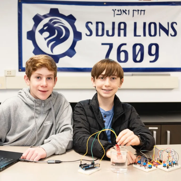 The CADENA Winners pose together in front of an SDJA banner.