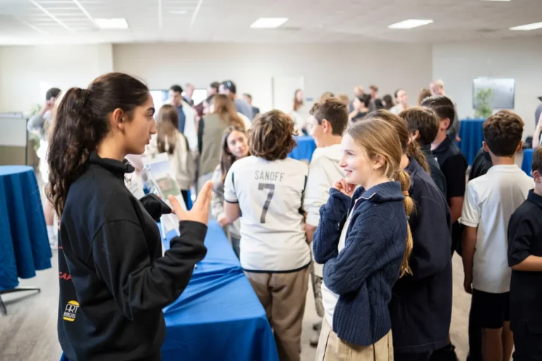 A student presents her project to another student at SDJA