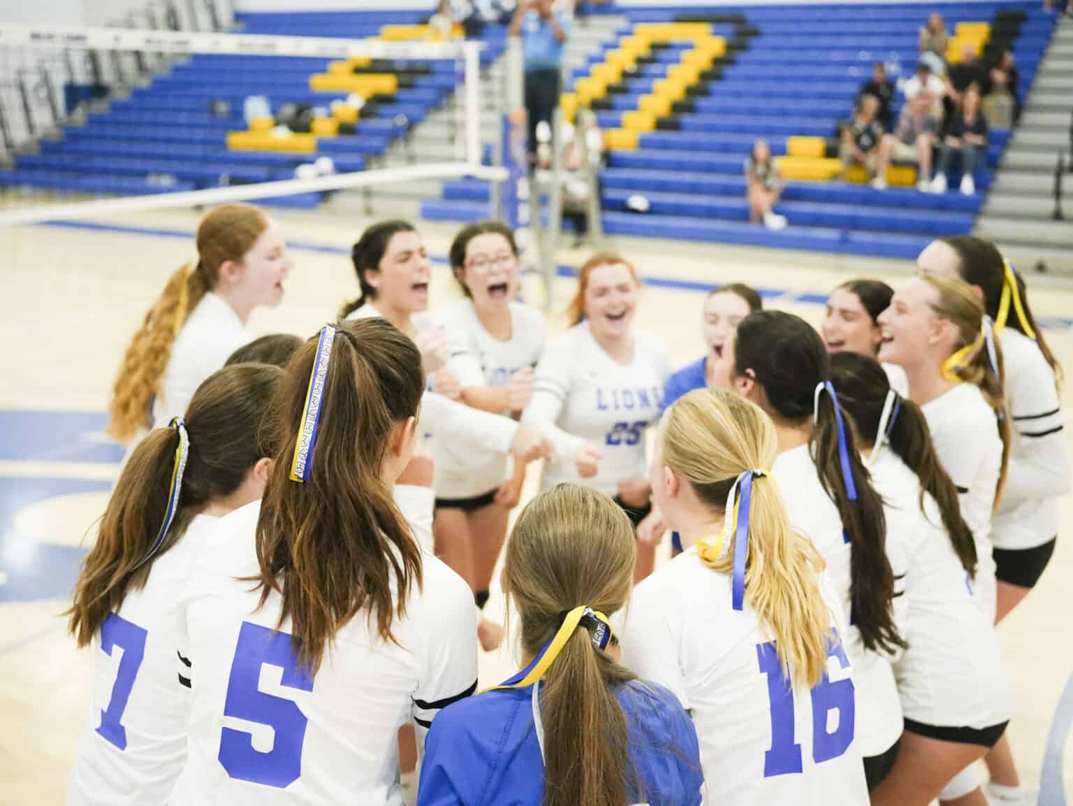 Girls cheering during an SDJA volleyball game.