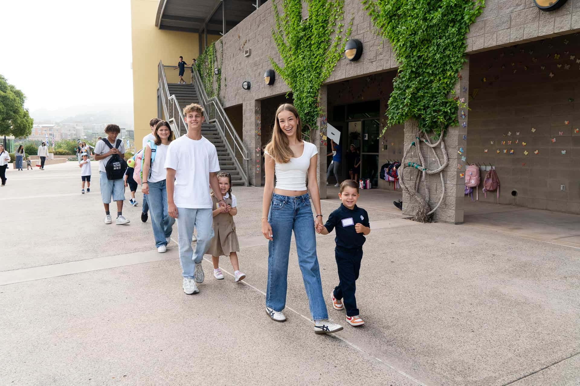 High school students walk elementary school students to class