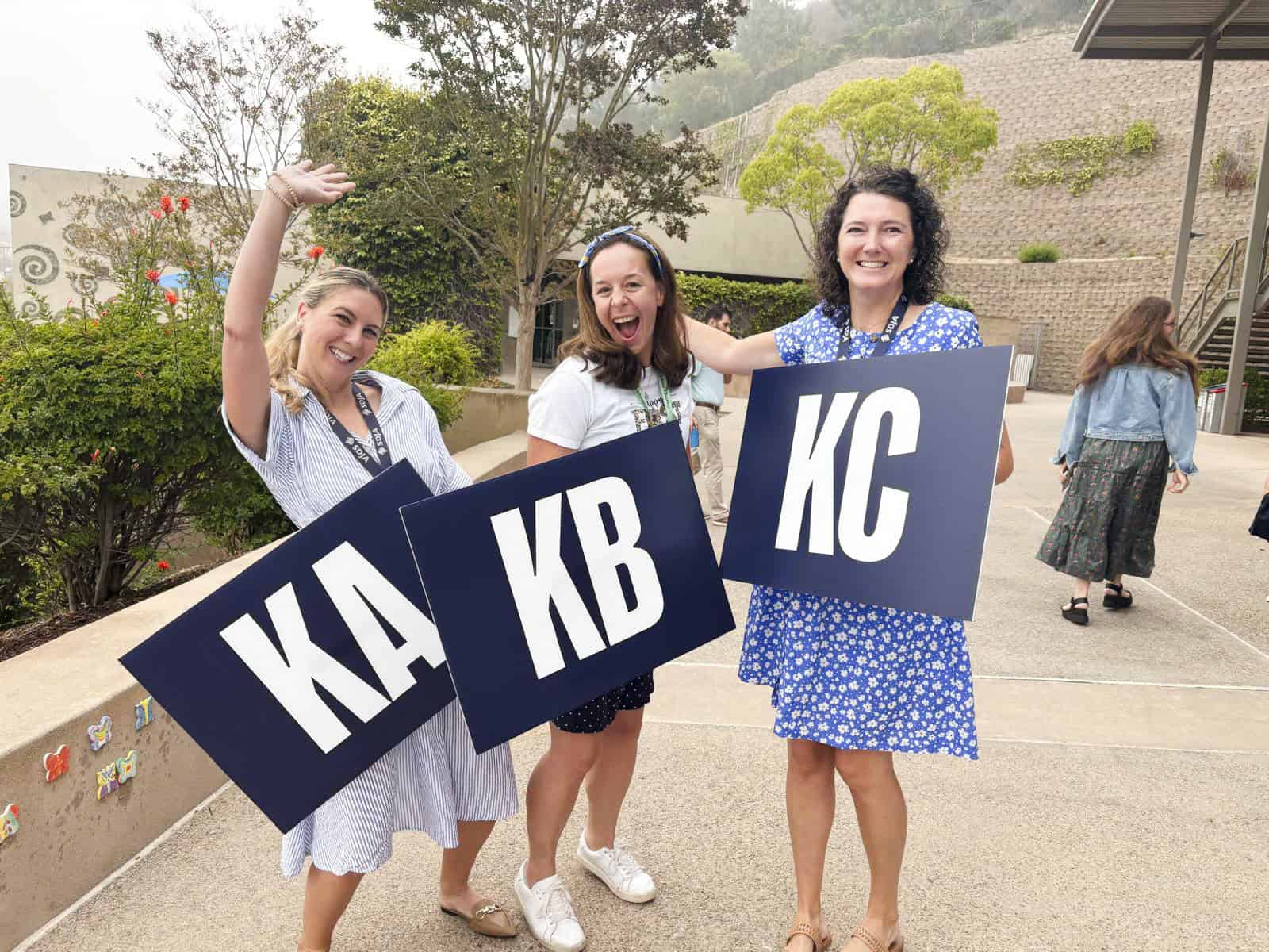Three SDJA team members posting with signs