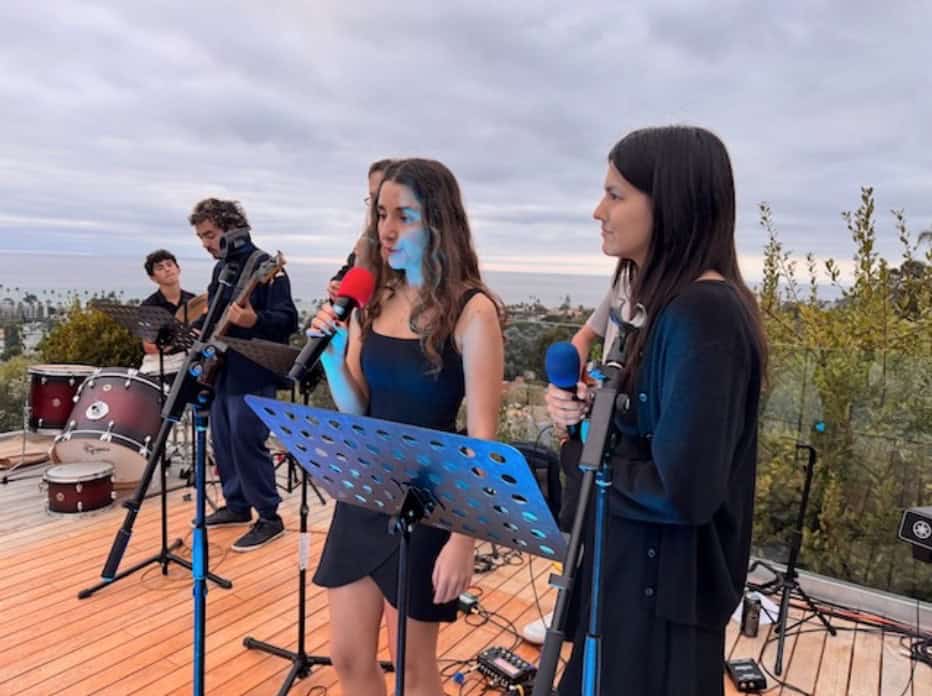 Students singing and playing instruments outdoors