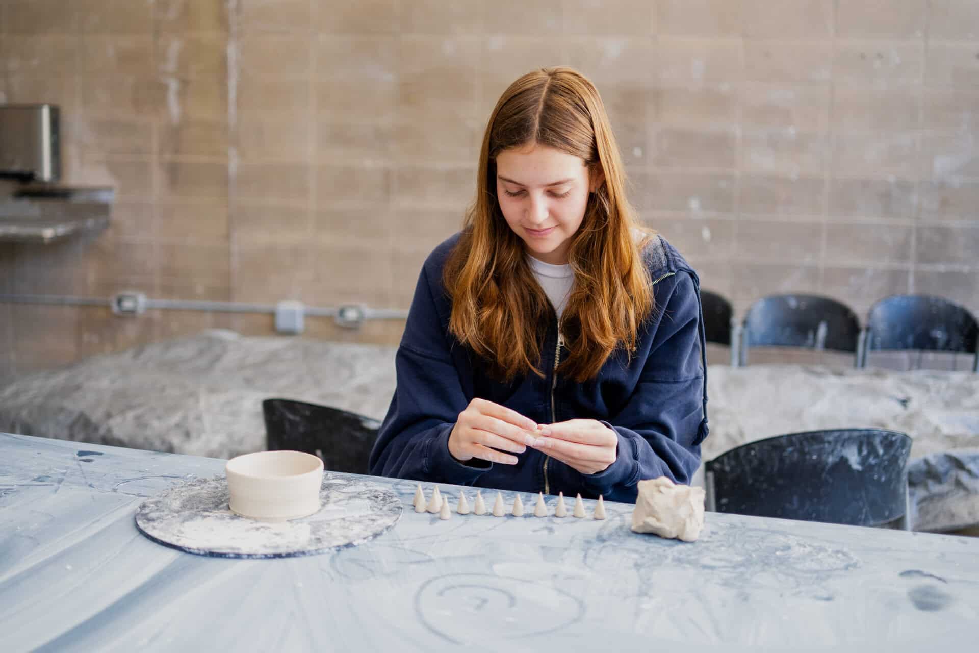 A girl making a clay sculpture