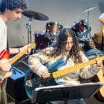 Students during band practice, holding guitars as basses