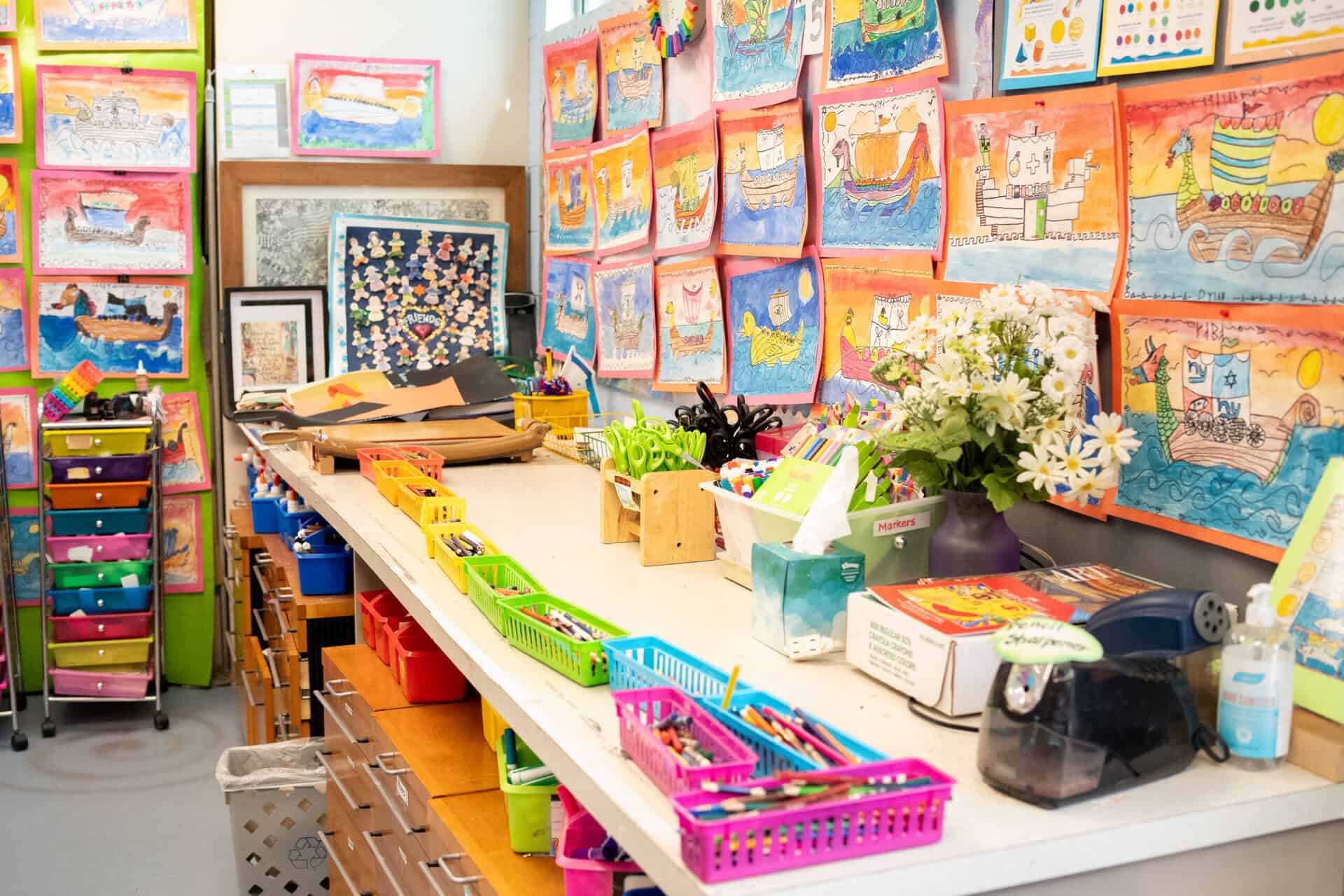 The counters and walls of the lower school art classroom, with baskets of pencils and hanging art pieces
