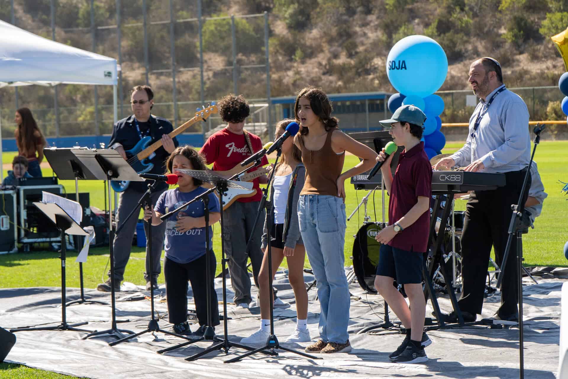 SDJA students and teachers performing music outdoors during Grandparents Day