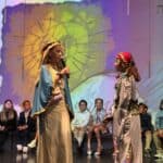 Students in costume on stage during a lower school performance