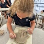 Lower school student making Jewish clay sculpture art