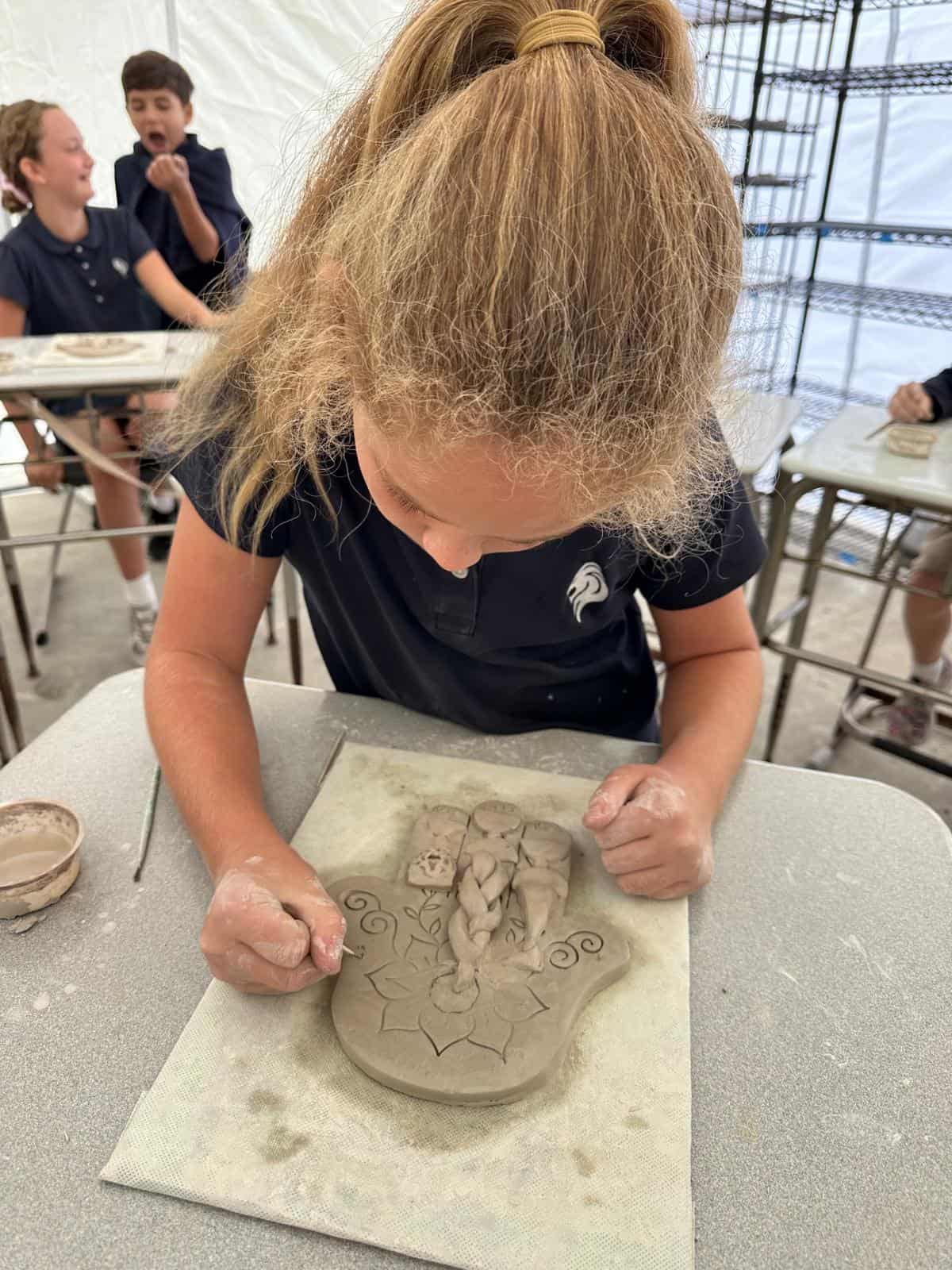 Lower school student making Jewish clay sculpture art