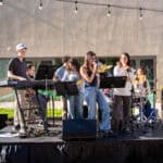 A student band performing music on an outdoor stage.