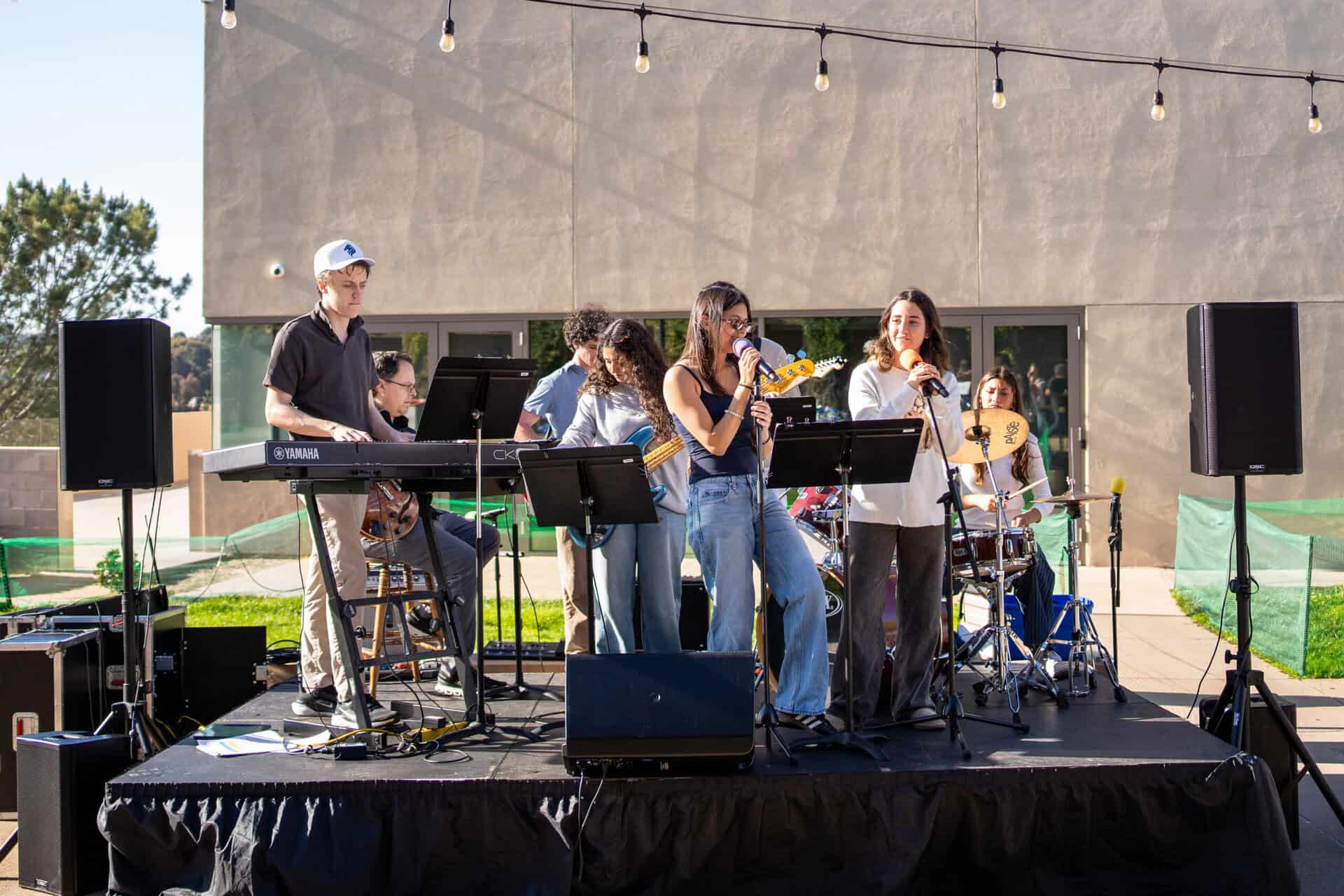 A student band performing music on an outdoor stage.