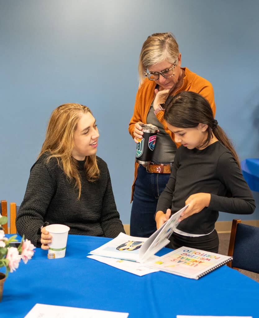 A 3rd grade student looks at a book during the Book Cafe event at SDJA