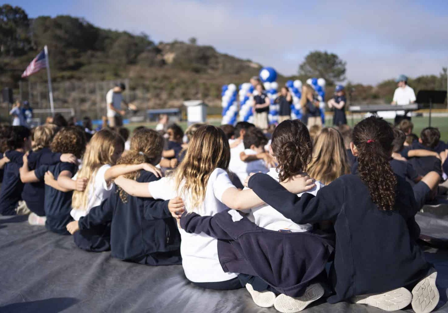 Students with arms around each other on the SDJA field