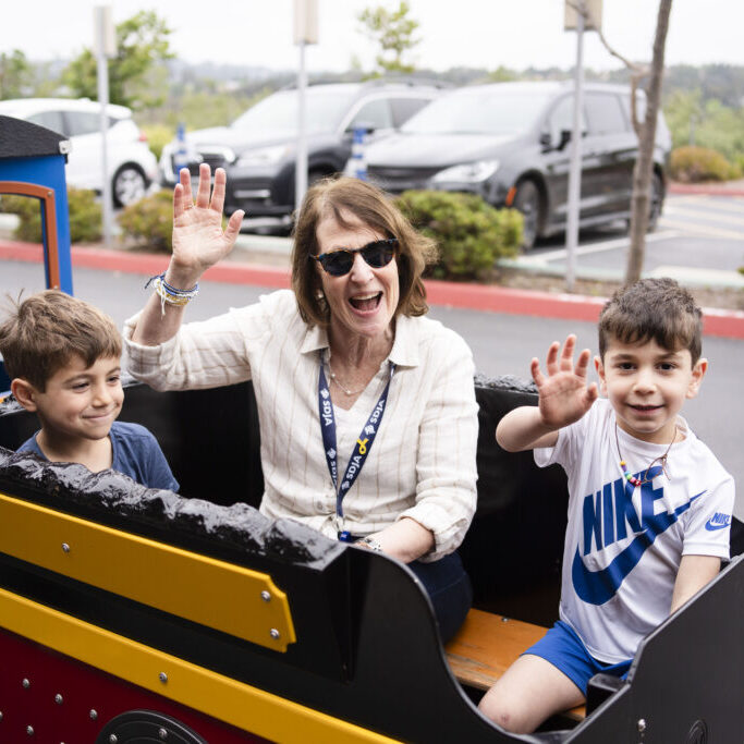 Preschool train A woman and two preschool children wave from a train