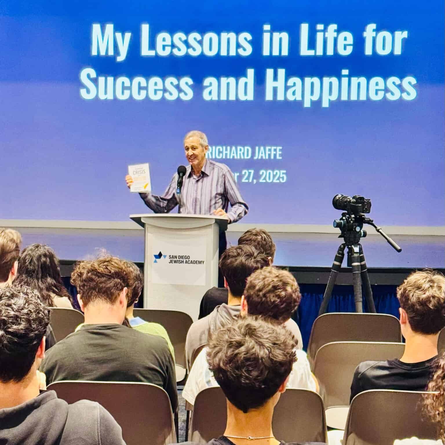 A mentor giving a presentation to students at SDJA. The background of the screen behind the presenter says "My lessons in life for success and happiness".